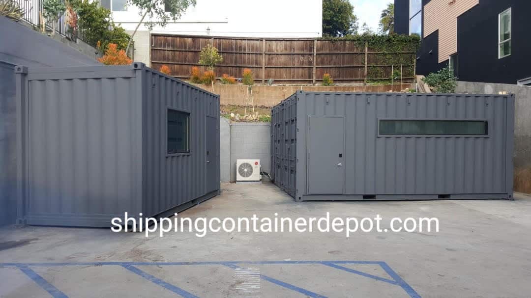 Two modified grey container offices with a personnel door and window strip