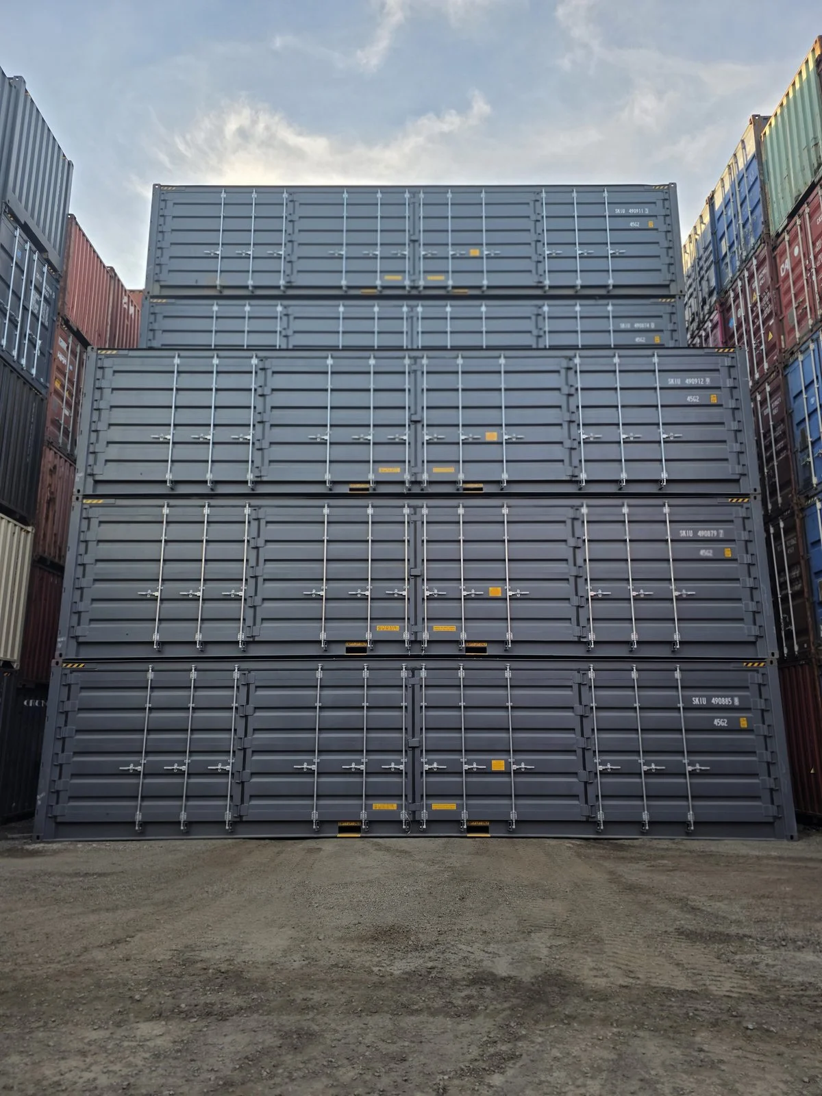 Grey 40ft open-side shipping containers stacked three high